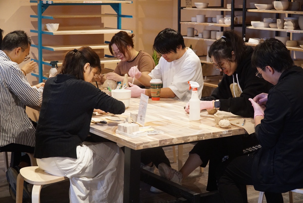 Group gathered around a table during a pottery class